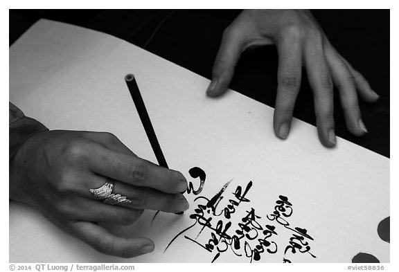 Feminine hand draws Lunar New Year greetings in fancy writing. Ho Chi Minh City, Vietnam (black and white)