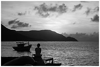 Silhouetted woman watching sunrise from Wharf 914, Con Son. Con Dao Islands, Vietnam ( black and white)