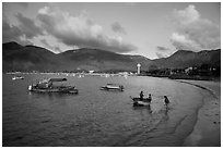 Woman collects catch from fishermen on coracle boat, Con Son. Con Dao Islands, Vietnam ( black and white)