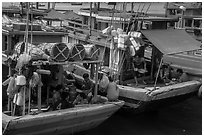 Sailors and families take lunch break at the back of boats, Ben Dam. Con Dao Islands, Vietnam ( black and white)