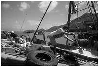 Man scoops ice into fishing boat, Ben Dam. Con Dao Islands, Vietnam ( black and white)
