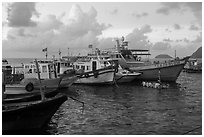 Fishing boats and man standing on raft, early morning, Con Son harbor. Con Dao Islands, Vietnam ( black and white)