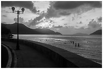 Seafront promenade and beachgoers at sunrise, Con Son. Con Dao Islands, Vietnam ( black and white)