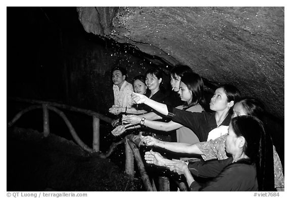 Women catch the water seeping from Tan Thanh Cave, said to have mirculous properties. Lang Son, Northest Vietnam
