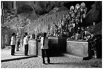 Women praying at the altar at the entrance of Tan Thanh Cave. Lang Son, Northest Vietnam (black and white)