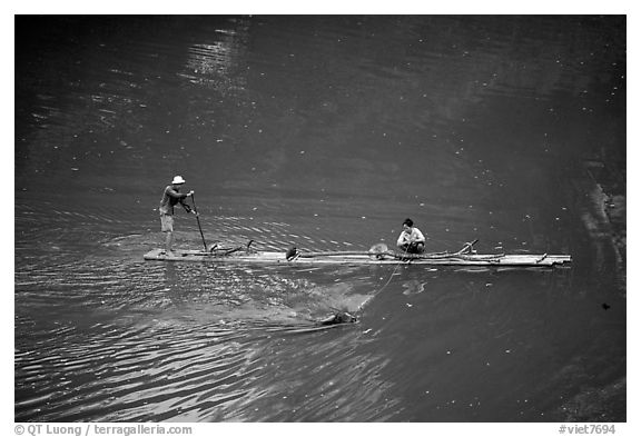Crossing the Ky Cung  River on a narrow dugout boat. Northest Vietnam (black and white)