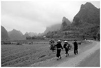 Villagers walking down the road with limestone peaks in the background, Ma Phuoc Pass area. Northeast Vietnam (black and white)