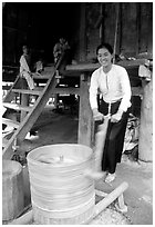Woman of the Thai ethnicity milling grain, near Mai Chau. Northwest Vietnam (black and white)
