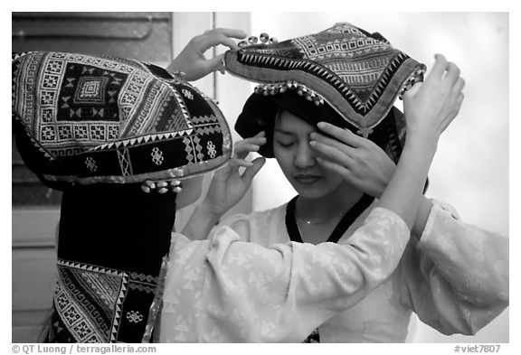 A thai woman helps her friend with her elaborate headdress, Son La. Northwest Vietnam