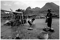 Thai women washing laundry and collecting water plants near an irrigation wheel, near Son La. Northwest Vietnam ( black and white)