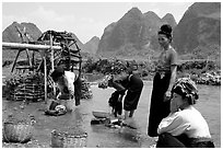 Thai women washing laundry and collecting water plants near an irrigation wheel, near Son La. Northwest Vietnam (black and white)