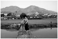 Thai woman pushing her bicycle across a bridge, Tuan Giao. Northwest Vietnam (black and white)