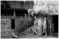 Woman in front of her hut and family on stilt house, between Lai Chau and Tam Duong. Northwest Vietnam (black and white)