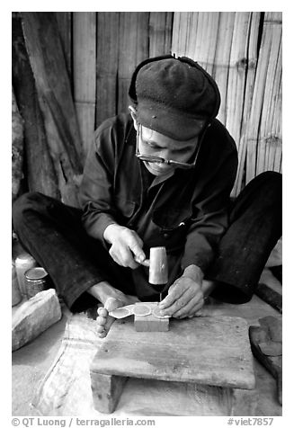 Dzao man crafting the decorative coins used in the children hats, between Tam Duong and Sapa. Northwest Vietnam