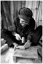 Dzao man crafting the decorative coins used in the children hats, between Tam Duong and Sapa. Northwest Vietnam (black and white)