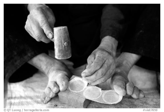 Hands and feet of a Black Dzao man making decorative coins, between Tam Duong and Sapa. Northwest Vietnam (black and white)