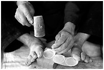 Hands and feet of a Black Dzao man making decorative coins, between Tam Duong and Sapa. Northwest Vietnam ( black and white)