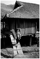Montagnard child carries logs out of her house, between Tuan Giao and Lai Chau. Northwest Vietnam ( black and white)
