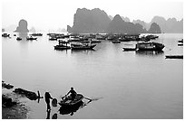Rowboat meeting woman on shore. Halong Bay, Vietnam ( black and white)
