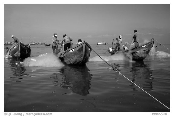Fishermen get their nets out of their small fishing boats. Vung Tau, Vietnam (black and white)