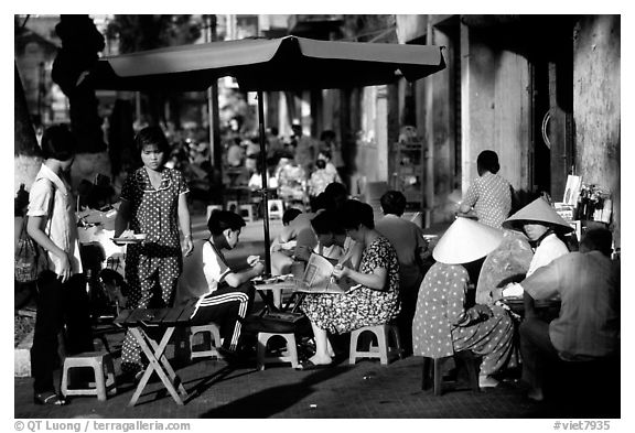 Eating in a street restaurant. Ho Chi Minh City, Vietnam (black and white)