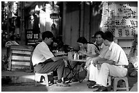 Enjoying a cafe on the streets, sitting on the typical tiny chairs. Ho Chi Minh City, Vietnam (black and white)