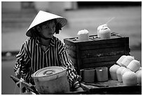 Coconut street vendor. The sweet juice is drank directly from a straw.. Ho Chi Minh City, Vietnam (black and white)