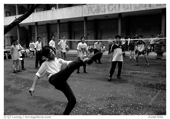 Students playing foot-only volley-ball in a school courtyard. Ho Chi Minh City, Vietnam (black and white)