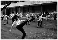Students playing foot-only volley-ball in a school courtyard. Ho Chi Minh City, Vietnam ( black and white)