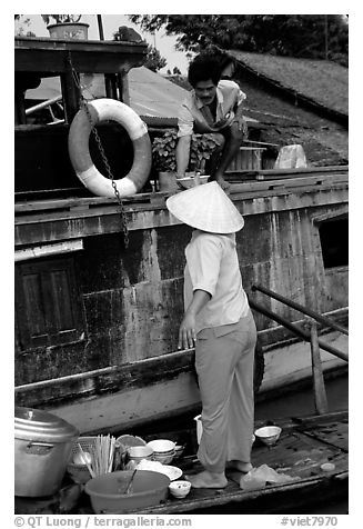 Passsing a bowl of pho from boat to boat. Can Tho, Vietnam (black and white)