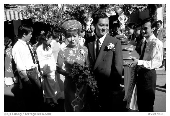 Newly-wed couple exit the bride's home. Ho Chi Minh City, Vietnam (black and white)
