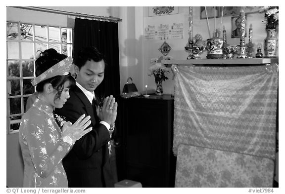 Newly-wed couple prays at the groom's ancestral altar. Ho Chi Minh City, Vietnam