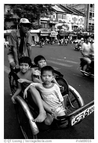 Kids sharing cyclo ride, Ho Chi Minh city. Vietnam (black and white)