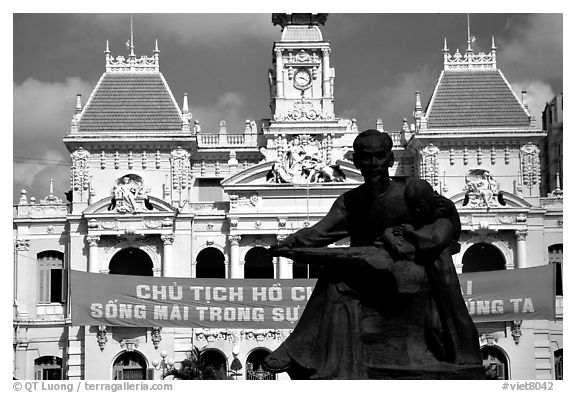 Bronze memorial to Ho Chi Minh by artist Diep Minh Chau and city hall. Ho Chi Minh City, Vietnam (black and white)