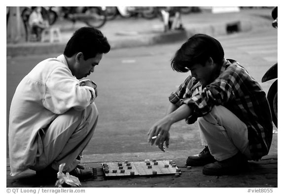 Chinese Chess game. Vietnamese people can sit on their heels for hours. Ho Chi Minh City, Vietnam (black and white)