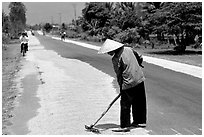 Rice being dried on sides of road. Mekong Delta, Vietnam ( black and white)