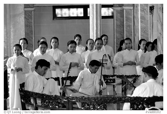 Traditional musicians during the noon ceremony. Tay Ninh, Vietnam (black and white)