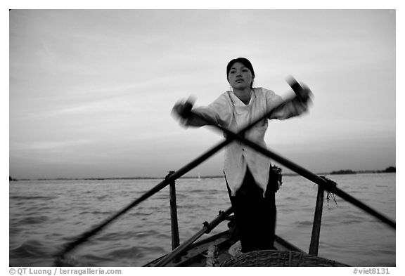 Woman using the X-shaped  paddle characteristic of the Delta. Can Tho, Vietnam (black and white)