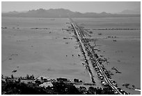 Stilts houses line a road traversing inundated rice fields, seen from Sam mountain. Cambodia is in the far. Chau Doc, Vietnam ( black and white)