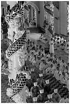 Priests and ornate columns inside the Great Caodai Temple. Tay Ninh, Vietnam ( black and white)