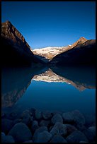 Boulders, Mirror-like Lake Louise and Victoria Peak, early morning. Banff National Park, Canadian Rockies, Alberta, Canada ( color)