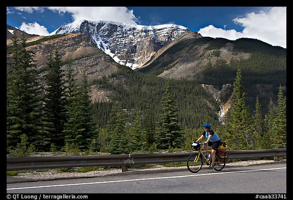 Woman cycling the Icefields Parkway. Jasper National Park, Canadian Rockies, Alberta, Canada (color)