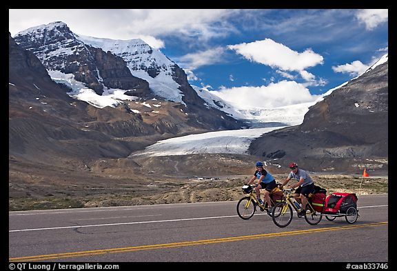 Cyclists on the Icefields Parkway in front of the Athabasca Glacier. Jasper National Park, Canadian Rockies, Alberta, Canada (color)