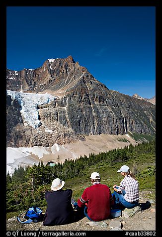 Hikers sitting in front of Mt Edith Cavell next to trail. Jasper National Park, Canadian Rockies, Alberta, Canada