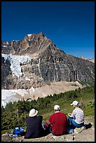 Hikers sitting in front of Mt Edith Cavell next to trail. Jasper National Park, Canadian Rockies, Alberta, Canada (color)