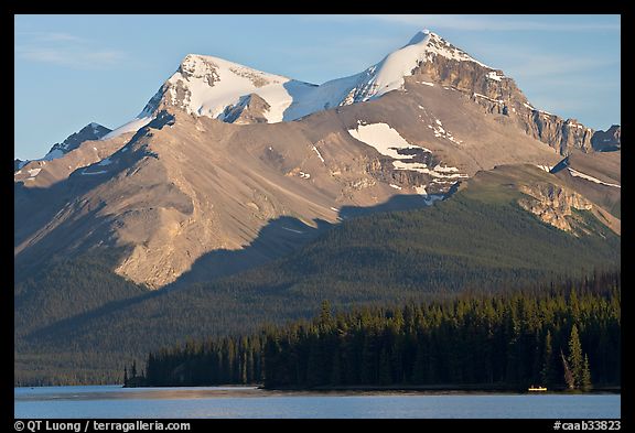 Canoe dwarfed by the Mt Charlton and Mt Unwin surrounding Maligne Lake. Jasper National Park, Canadian Rockies, Alberta, Canada (color)