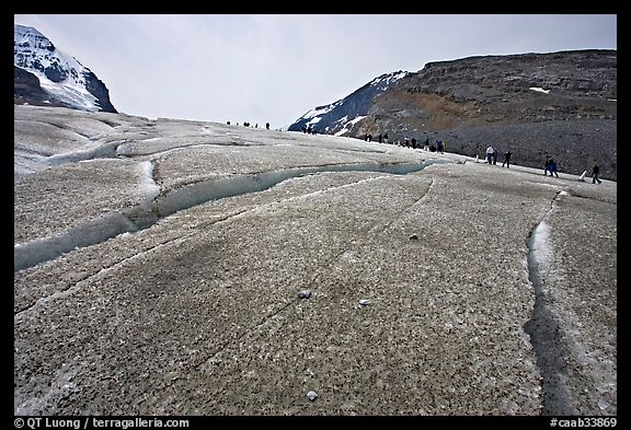 Crevasses on Athabasca Glacier with a line of tourists in the background. Jasper National Park, Canadian Rockies, Alberta, Canada