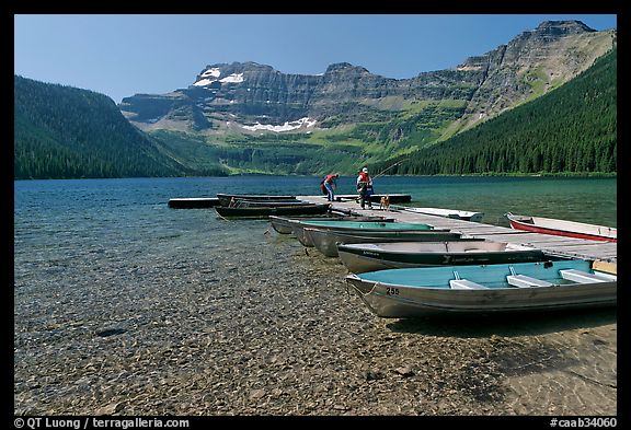 Fishermen walking on dock after unloading a canoe, Cameron Lake. Waterton Lakes National Park, Alberta, Canada (color)