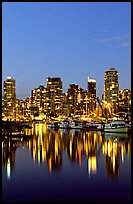 Fishing boats and skyline light reflected at night. Vancouver, British Columbia, Canada