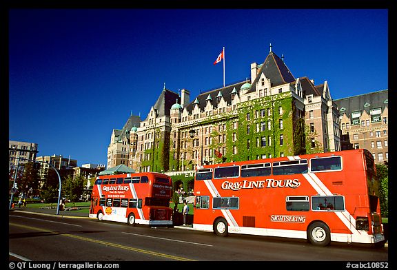 Red double-decker tour busses in front of Empress hotel. Victoria, British Columbia, Canada (color)